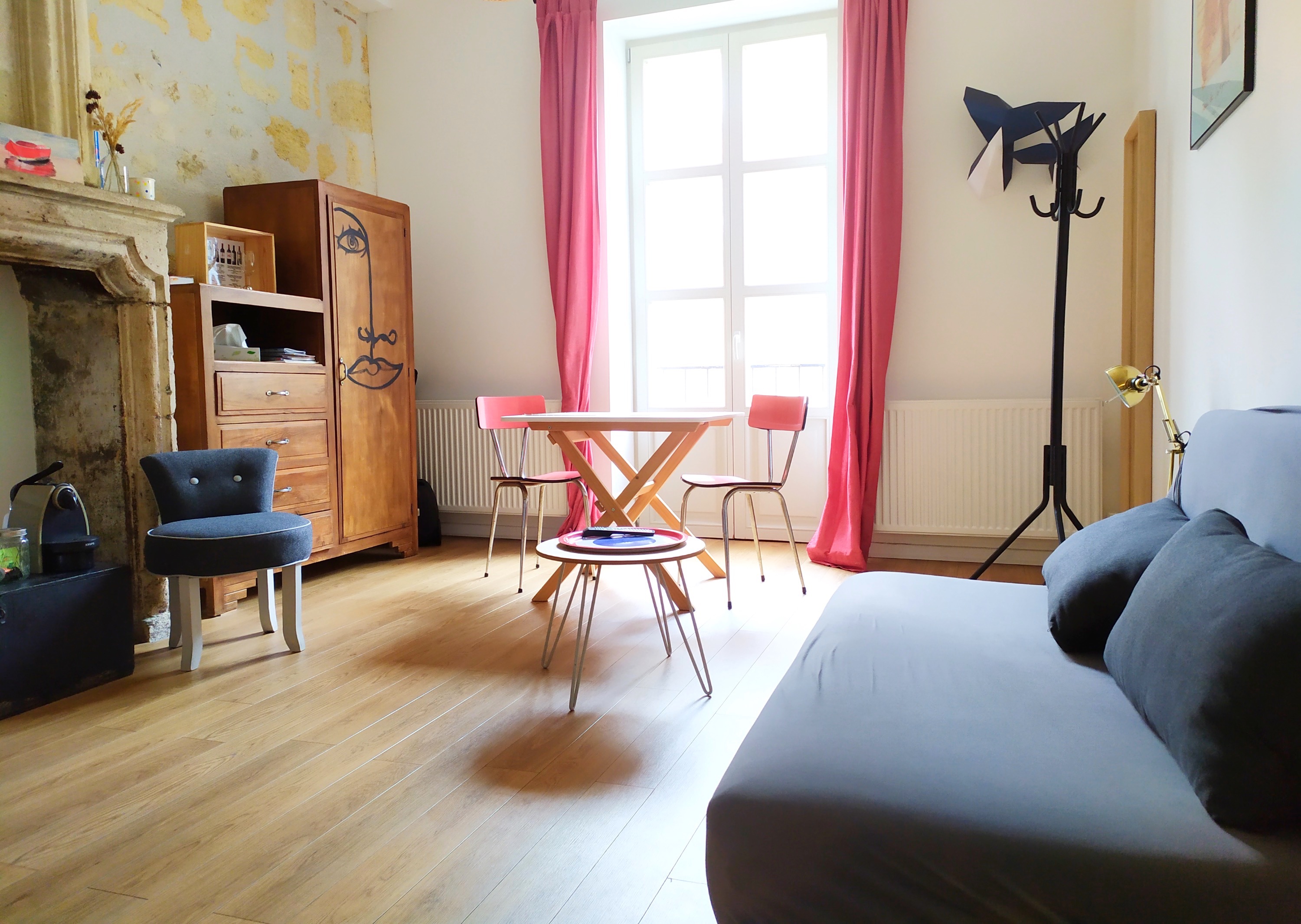 Salon avec décoration rouge et cheminée, Studio Rouge B&B Bordeaux Saint Michel